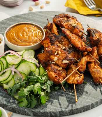 Air fryer chicken satay skewers served with peanut sauce and pickled cucumber salad
