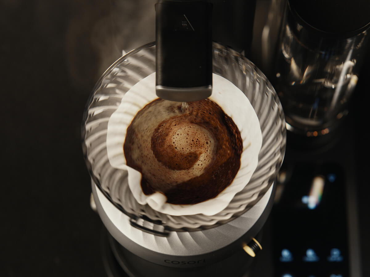 Pour-over coffee dripper with bloomed grounds, showing the coffee brewing process