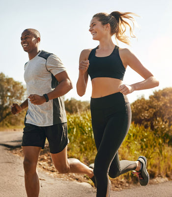 Two people running side by side outdoors, symbolizing fitness, energy balance, and healthy habits for muscle gain and fat loss