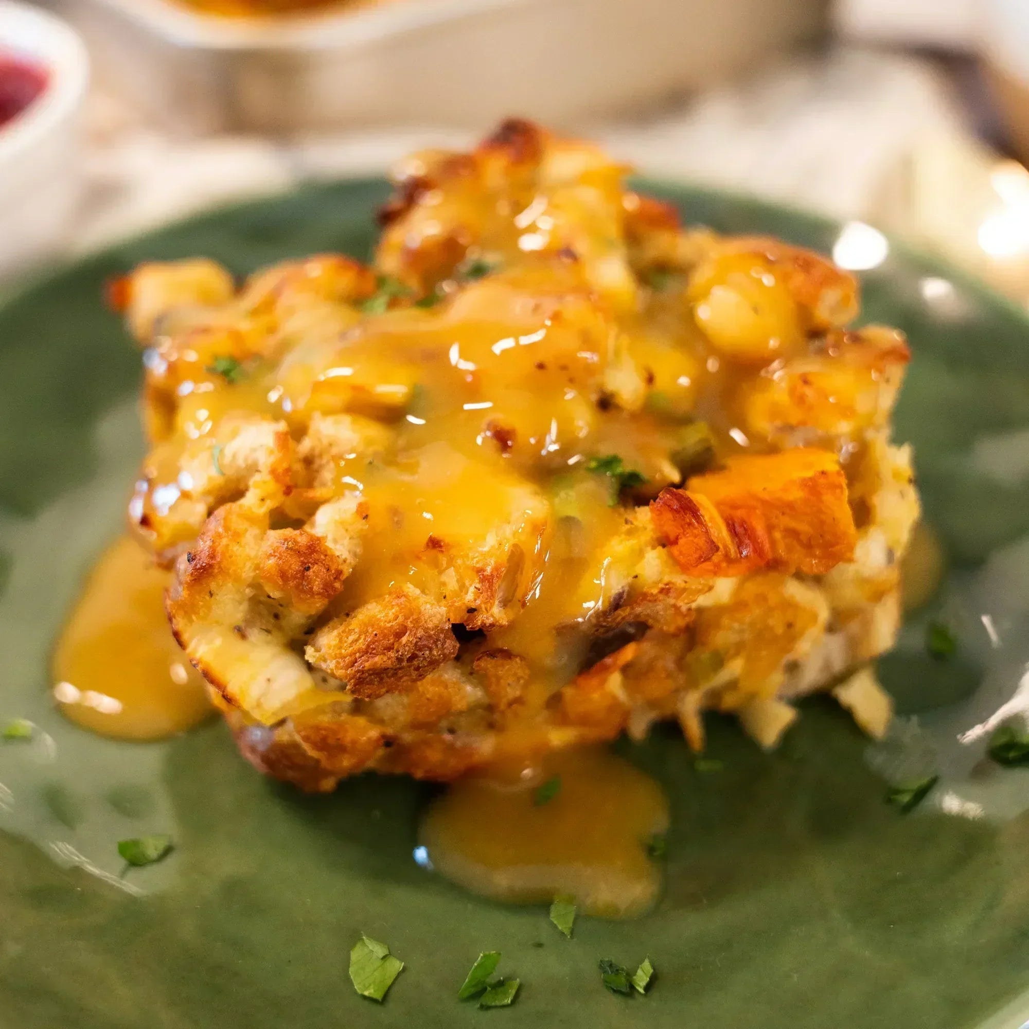 A savory Thanksgiving bread pudding covered in rich, golden-brown gravy