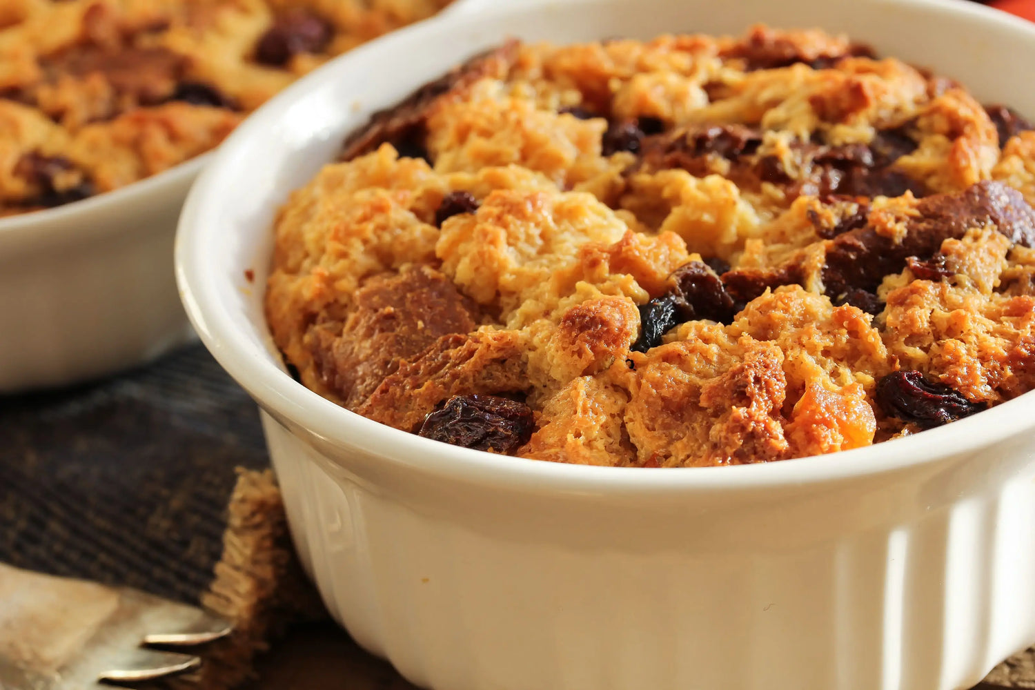 Golden brown Thanksgiving leftover bread pudding baked in a small white ramekin