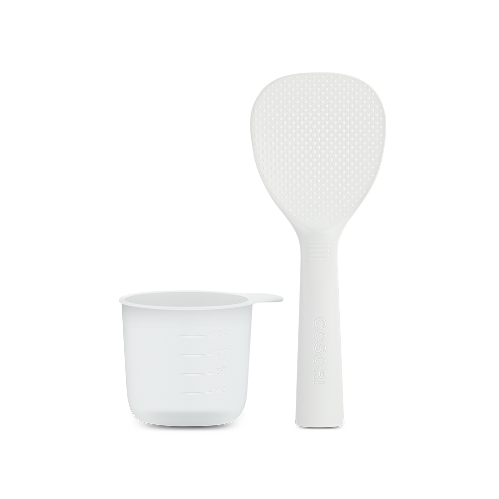 Standing rice paddle and measuring cup accessories included with the Cosori Rice Cooker