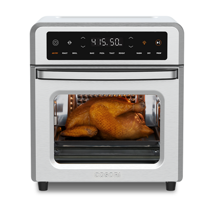 Cosori 13-Quart Air Fryer Oven with a whole roasted chicken cooking inside. Stainless steel finish