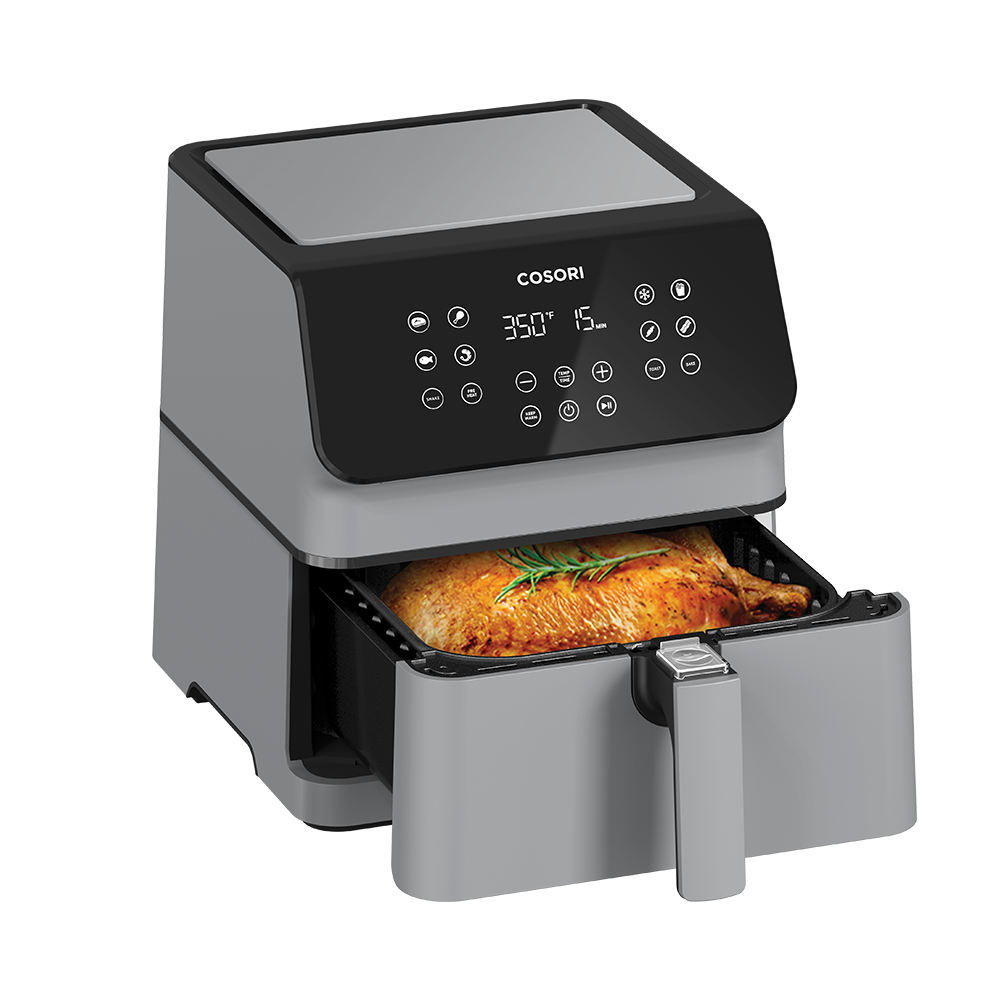 Cosori Pro II Air Fryer with basket pulled open revealing a whole roasted chicken in the 5.8-quart basket