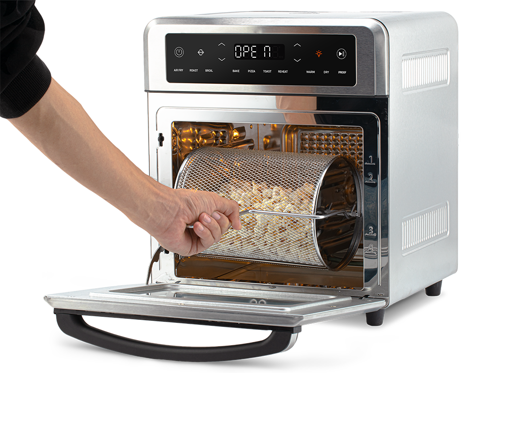 Removing the rotating mesh fry basket using the handle tool from the open Cosori Air Fryer Oven