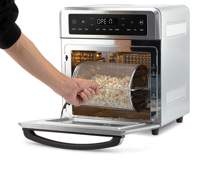 Removing the rotating mesh fry basket using the handle tool from the open Cosori Air Fryer Oven